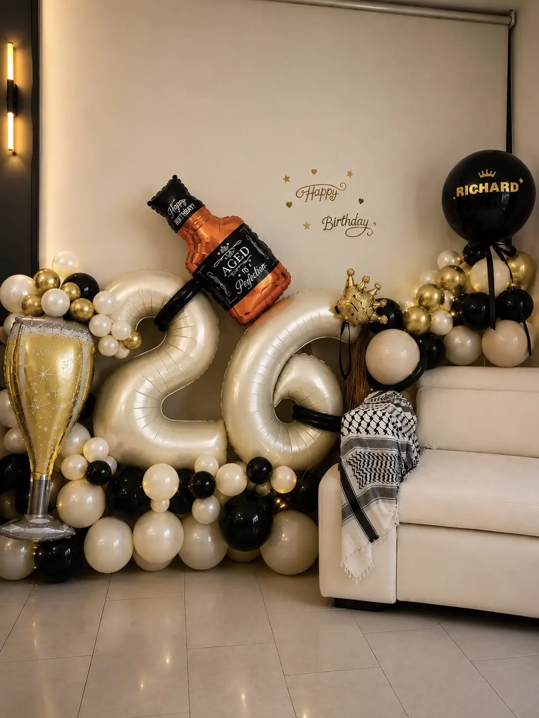 Luxury black, gold and ivory milestone birthday balloon setup with giant foil numbers, crown and bottle accents