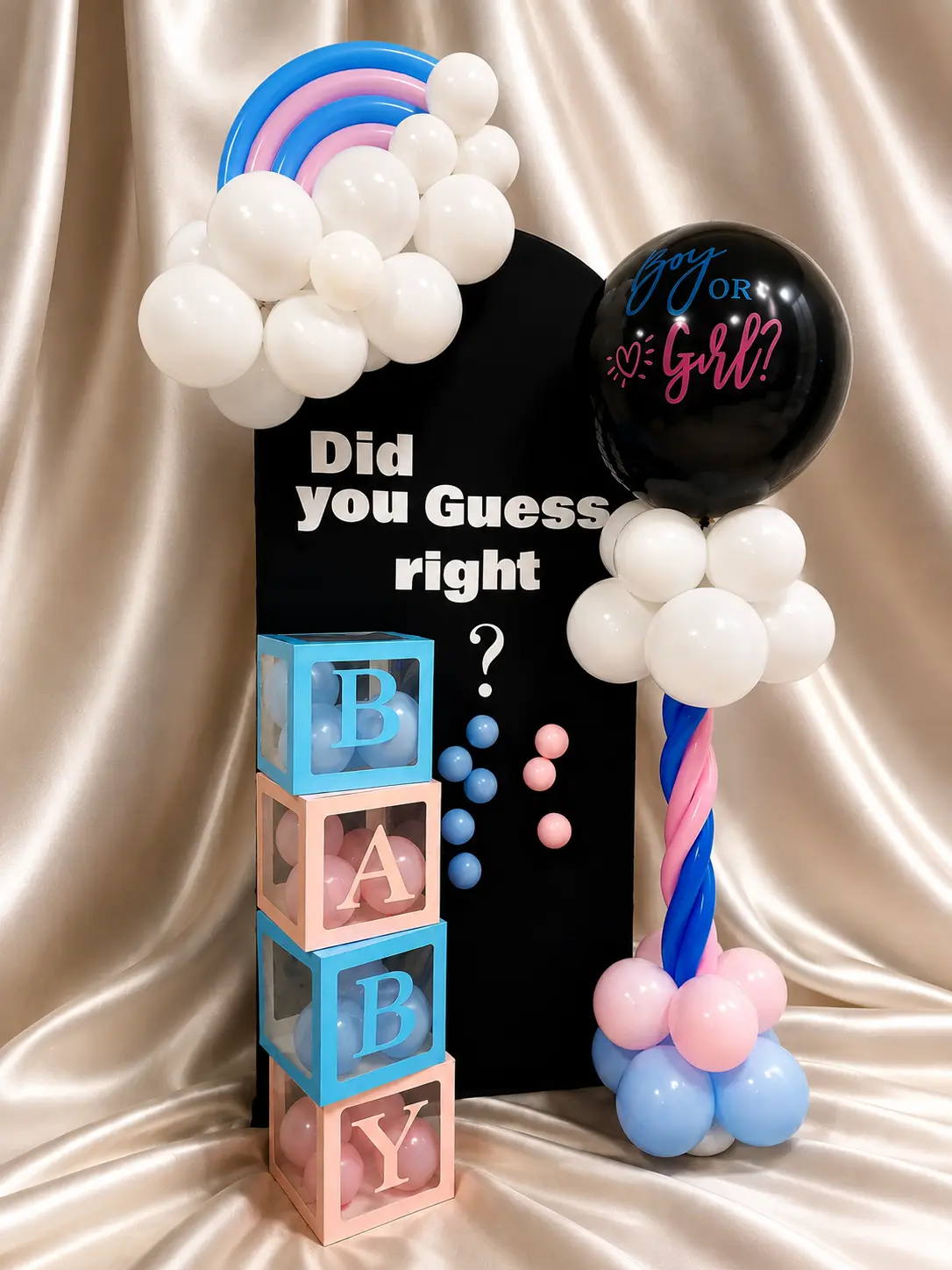 Boy or Girl gender reveal setup with a black reveal balloon, pink and blue balloons, and BABY boxes