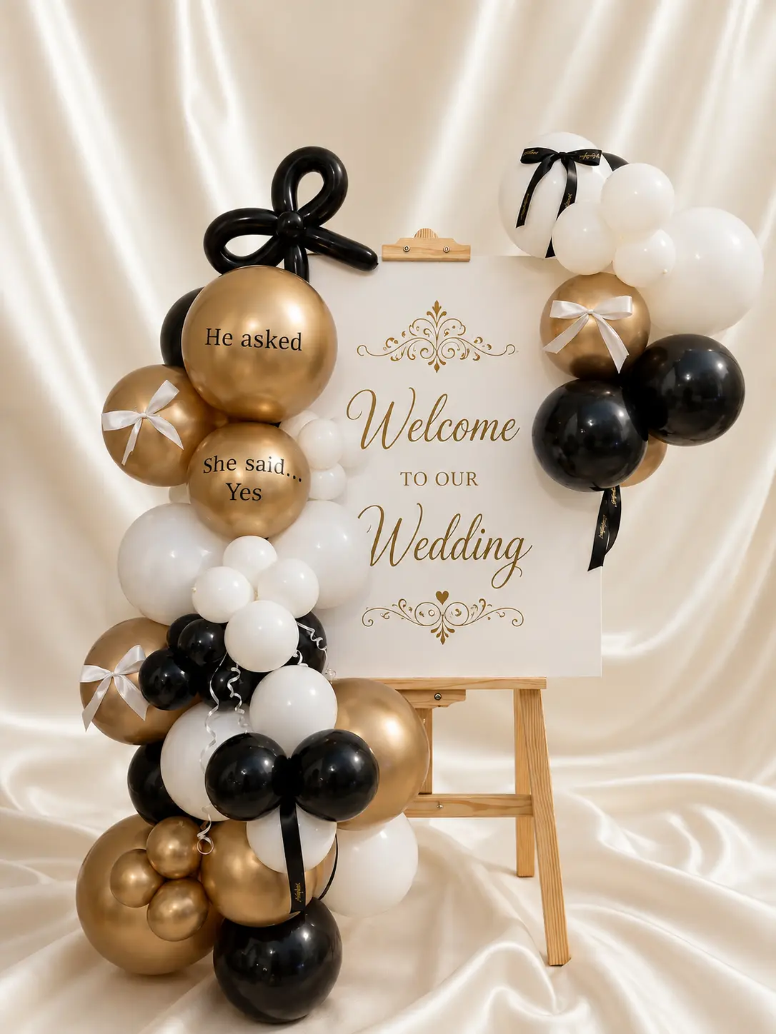 Wedding welcome display with black, white and gold balloons